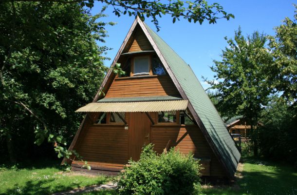 Typ D – Nurdachhaus 340 mit spitzem grünem Dach, Holzfassade und Naturumgebung