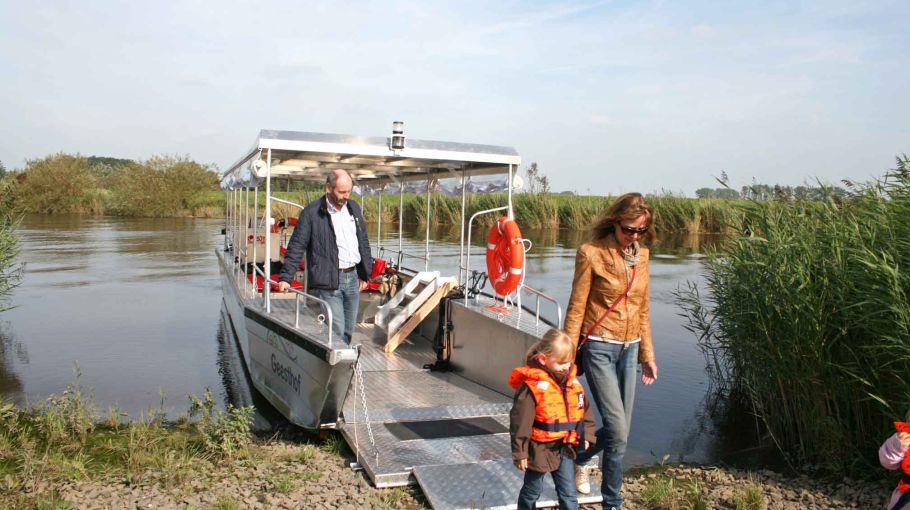 Foto des Ladungsbootes Püttenhüpper, von dem Passagiere an Land gehen.