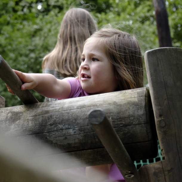 Foto von einem Kind, dass auf einem Spielschiff steht und das Steuer in der Hand hat.
