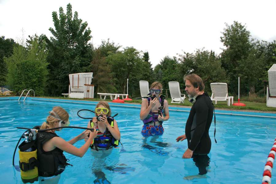 Foto einer Gruppe von Kindern, die mit einem Tauchlehrer im Außenbecken des Badeparadies stehen.