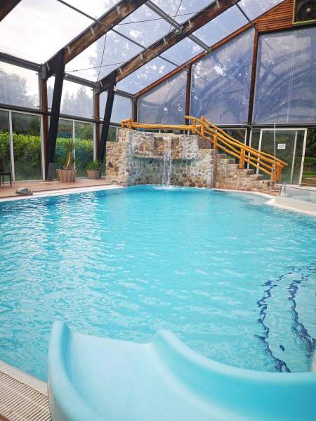 Foto eines Beckens im Schwimmbad "Badeparadies" mit Rutsche und Wasserfall.