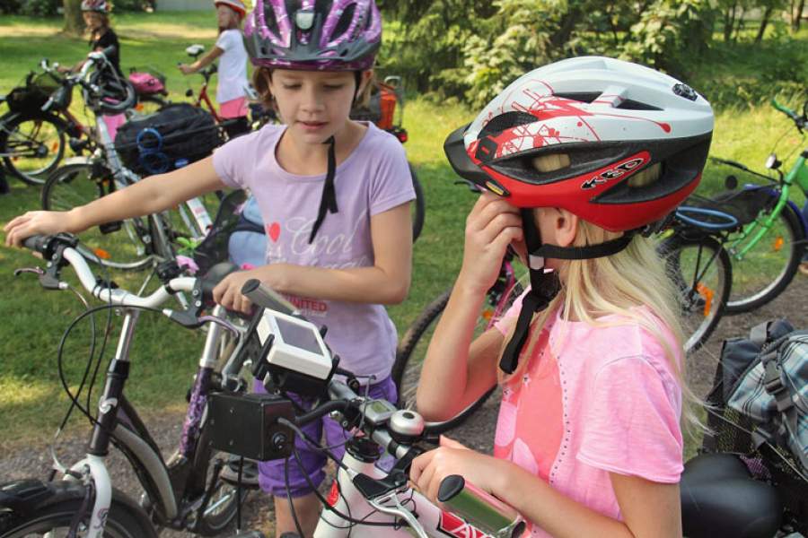 Foto von zwei Mädchen mit Fahrrädern und Fahrradhelmen.