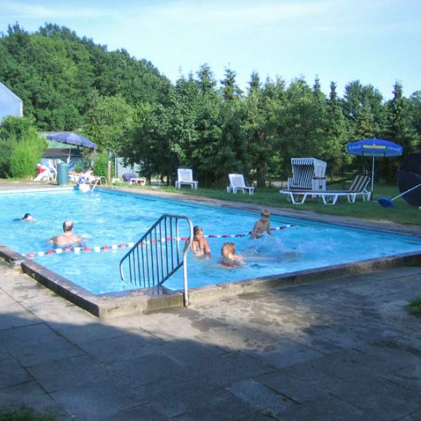 Foto des Außenbeckens mit Strandkorb im Sommer.